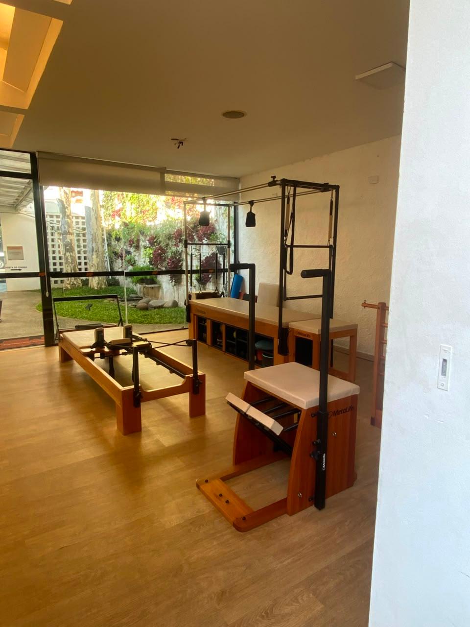 Sala de Pilates com equipamentos MetaLife e vista para o jardim